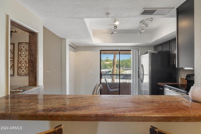 kitchen with stainless steel fridge, electric stove, visible vents, and a textured ceiling