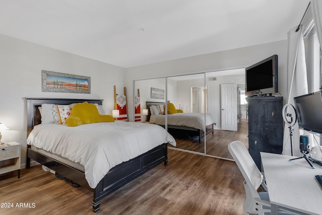 bedroom with a closet, baseboards, and wood finished floors