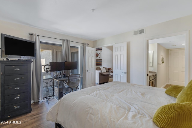 bedroom featuring dark wood-style floors, visible vents, and connected bathroom