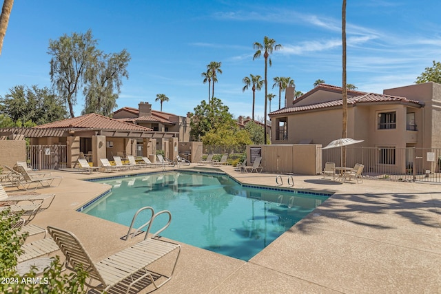 pool with a patio and fence