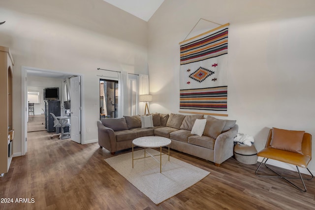 living room with a high ceiling, wood finished floors, and baseboards