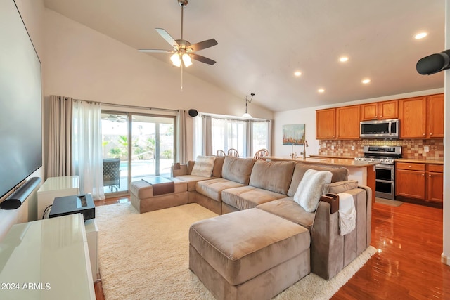 living room featuring ceiling fan, dark hardwood / wood-style flooring, and high vaulted ceiling