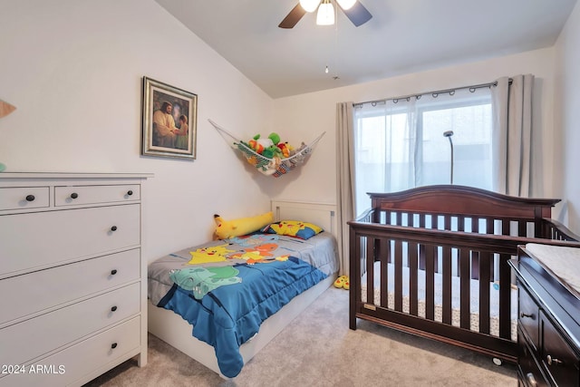 bedroom featuring vaulted ceiling, light carpet, and ceiling fan