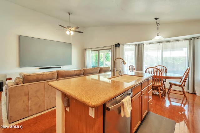 kitchen featuring light hardwood / wood-style floors, stainless steel dishwasher, lofted ceiling, and an island with sink