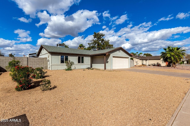 ranch-style house with a garage, concrete driveway, and fence