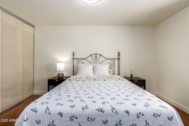 bedroom featuring dark wood-style floors and baseboards