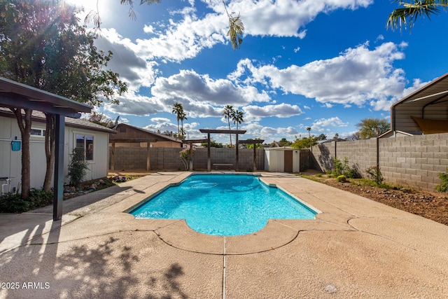 view of swimming pool featuring a fenced in pool, a patio area, a fenced backyard, and an outdoor structure