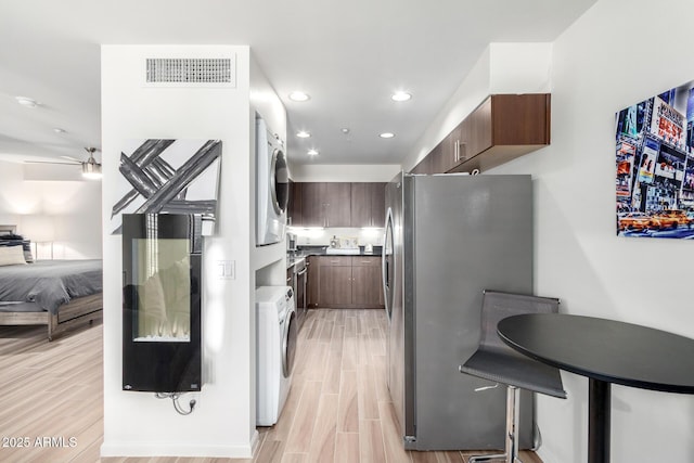 3635 N 68th St Unit 5, Scottsdale, AZ 85251 - kitchen with stacked washer / drying machine, freestanding refrigerator, light wood-style floors, open floor plan, and recessed lighting