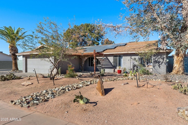 single story home with a garage and solar panels