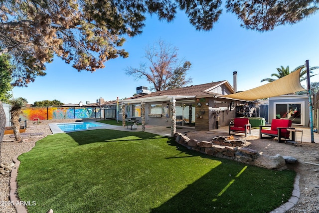 rear view of house with a yard, a fenced in pool, and a patio area