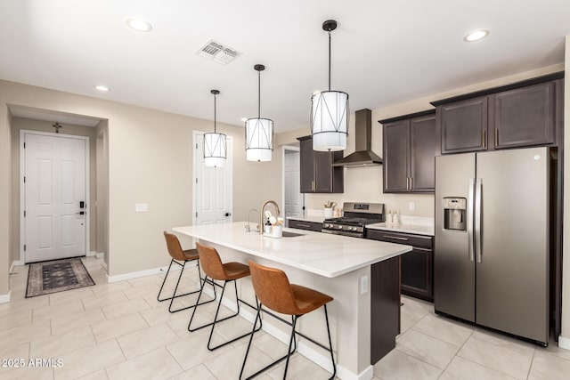 17918 W Toronto Way, Goodyear, AZ 85338 - kitchen featuring appliances with stainless steel finishes, wall chimney exhaust hood, a kitchen breakfast bar, light countertops, and dark brown cabinets