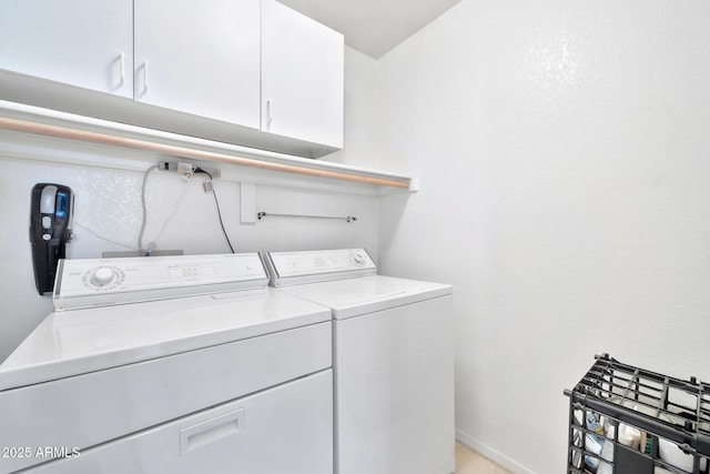 laundry room with washer and dryer and cabinets