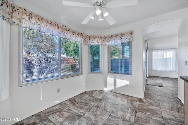 unfurnished dining area featuring ceiling fan and a healthy amount of sunlight