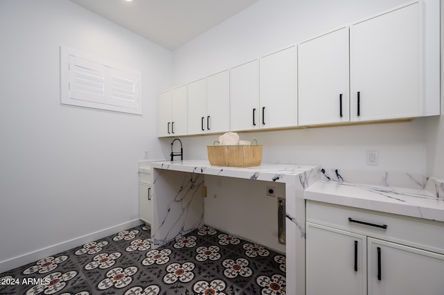 washroom with tile patterned flooring, cabinets, and hookup for an electric dryer