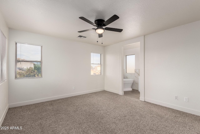 unfurnished bedroom with connected bathroom, carpet floors, a textured ceiling, and ceiling fan