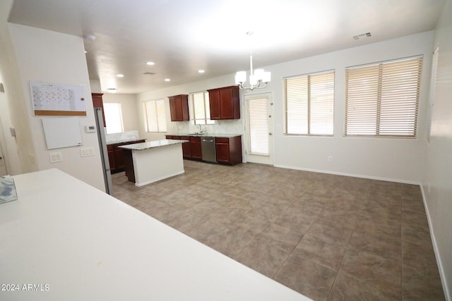 kitchen with sink, hanging light fixtures, a center island, a notable chandelier, and stainless steel appliances