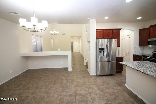 kitchen featuring stainless steel appliances, light stone counters, decorative backsplash, decorative light fixtures, and a chandelier