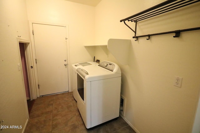 laundry room featuring washing machine and dryer and dark tile patterned floors