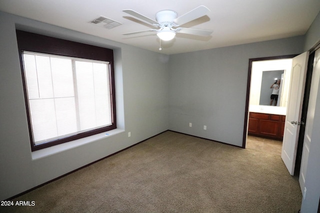 spare room featuring light carpet and ceiling fan