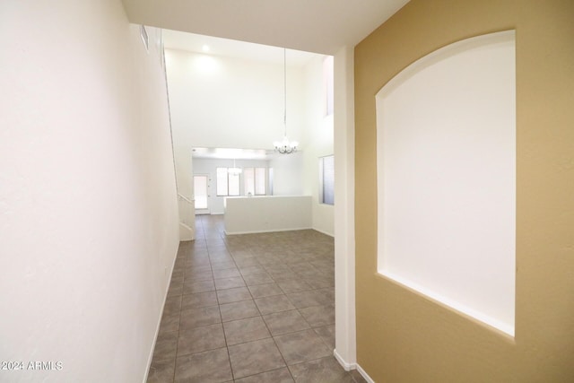 hallway featuring light tile patterned floors and a notable chandelier