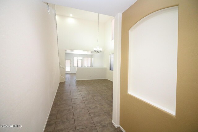 hall featuring a chandelier and dark tile patterned floors