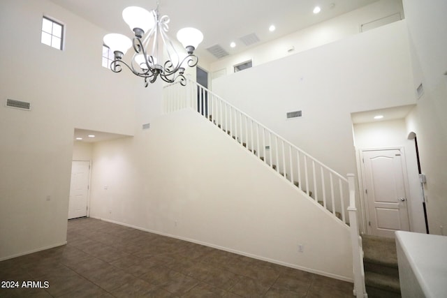 stairway featuring a chandelier and a high ceiling