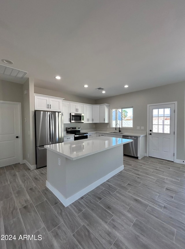 kitchen featuring white cabinetry, a center island, sink, and stainless steel appliances