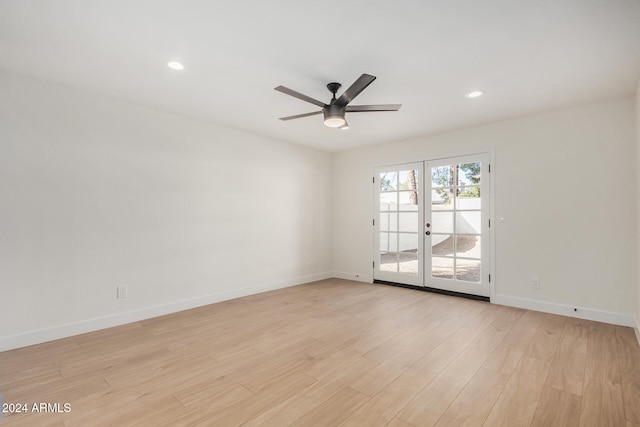 empty room with ceiling fan, light hardwood / wood-style flooring, and french doors