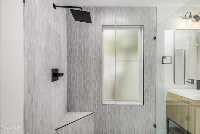 bathroom featuring a tile shower and vanity