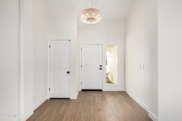 entryway with hardwood / wood-style flooring and an inviting chandelier