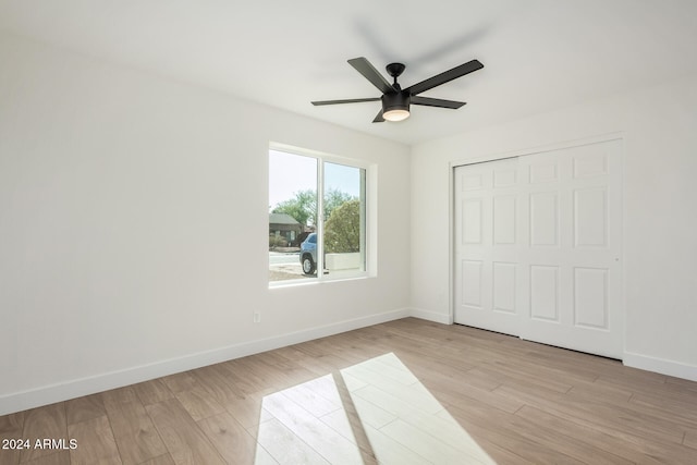 unfurnished bedroom with ceiling fan, a closet, and light wood-type flooring