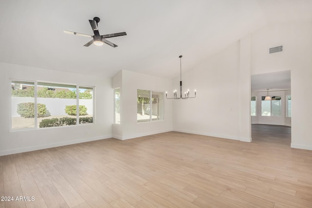 interior space featuring ceiling fan with notable chandelier, light wood-type flooring, and high vaulted ceiling