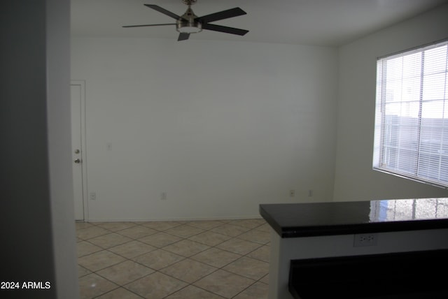 tiled empty room featuring ceiling fan