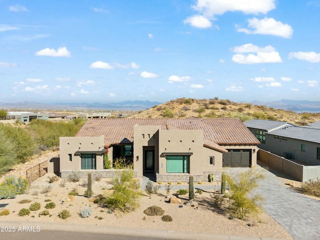 pueblo-style home with a mountain view and a garage