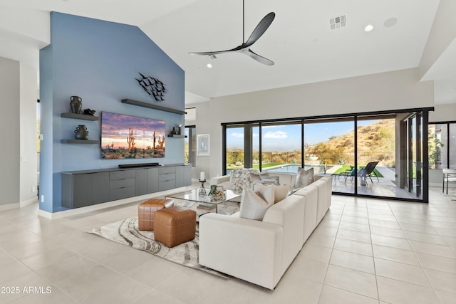 tiled living room featuring ceiling fan and high vaulted ceiling