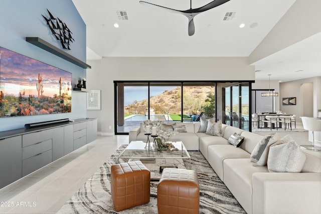 living room featuring ceiling fan, lofted ceiling, and light tile patterned floors