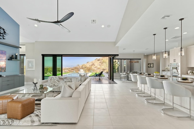 living room featuring sink, high vaulted ceiling, and light tile patterned flooring