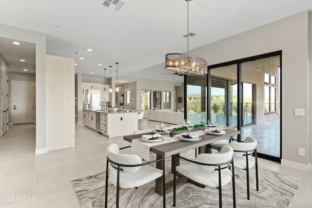 tiled dining space with a notable chandelier and sink