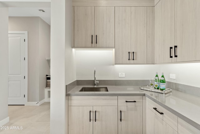 kitchen with sink, light tile patterned floors, and light brown cabinets