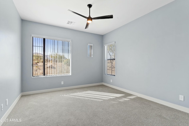 carpeted spare room featuring ceiling fan