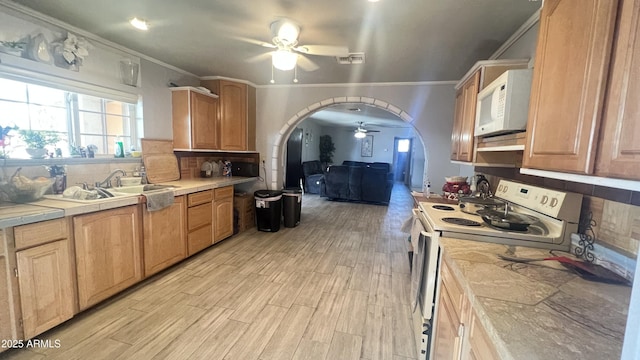 kitchen featuring tile countertops, tasteful backsplash, ceiling fan, white appliances, and light hardwood / wood-style flooring