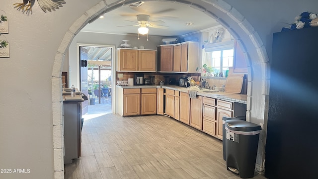 kitchen featuring tasteful backsplash, ornamental molding, sink, and ceiling fan