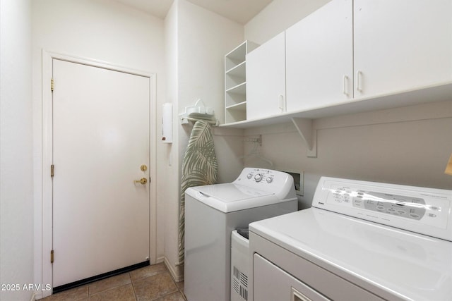 laundry room featuring cabinets, light tile patterned floors, and washing machine and clothes dryer