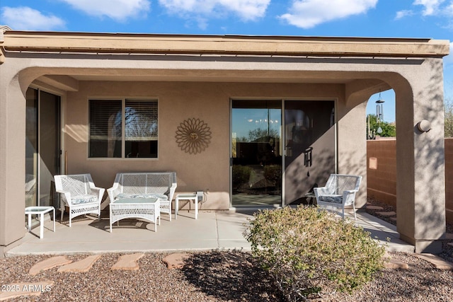 rear view of house with a patio area and stucco siding