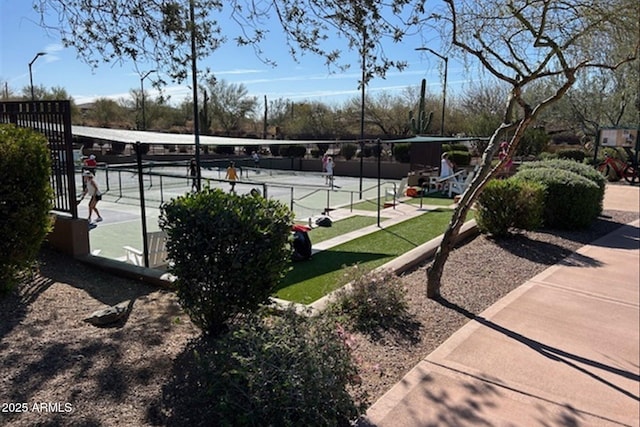 view of community with a tennis court and fence