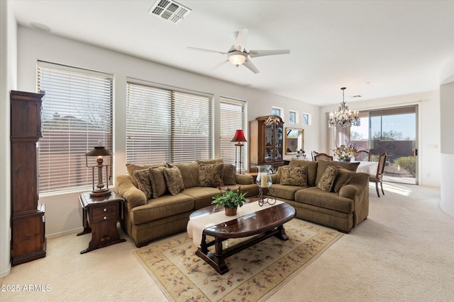 living room featuring light carpet and ceiling fan with notable chandelier