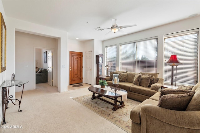 living area with light carpet, ceiling fan, and visible vents