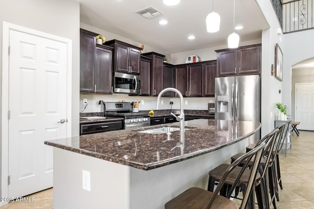 10840 W Saddlehorn Rd, Peoria, AZ 85383 - kitchen with a kitchen island with sink, dark brown cabinetry, and appliances with stainless steel finishes