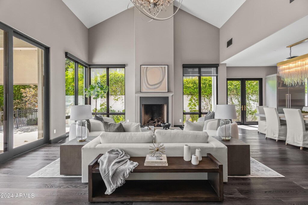 living room with dark hardwood / wood-style flooring, french doors, high vaulted ceiling, and a notable chandelier