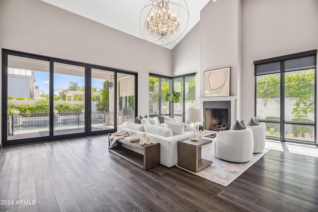 living room featuring hardwood / wood-style floors, high vaulted ceiling, and an inviting chandelier